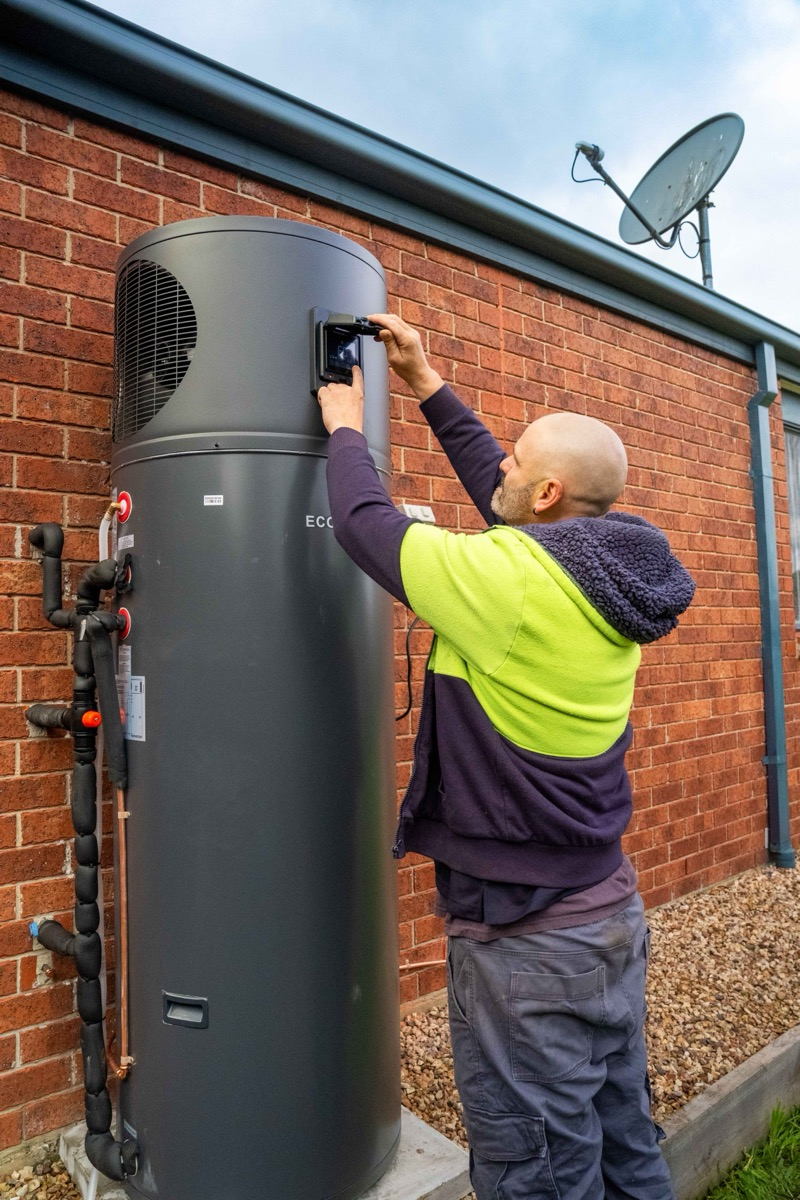 A Goldsure plumber checking the controls on an installed Econova heat pump